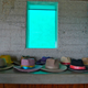 Hats on a shelf with windows looking out into the pond